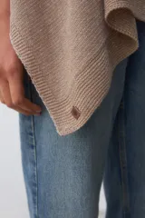 Poncho de tejido de punto color beige con hilo lurex plateado, de corte asimétrico y mangas amplias.