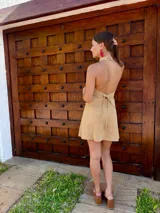 Top halter de cuero color beige, con cuello alto y ajuste mediante tiras en la espalda.