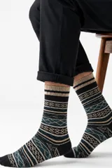 Media de caña media con diseño de tejido jacquard en tonos negro, beige y azul. Presenta un patrón geométrico y de rayas horizontales.