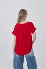 Blusa de poliéster color blanco con cuello en V, mangas cortas con dobladillo y corte holgado.