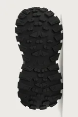 Zapatilla deportiva tipo running de color negro, confeccionada con una combinación de materiales y piezas, con suela robusta de gran volumen y diseño irregular.