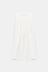 Pantalón ancho confeccionado en hilatura con lino, color blanco, de tiro alto con detalle de pinzas y lazada en la cintura.