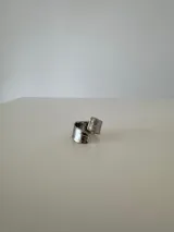 Anillo ajustable de acero quirúrgico con acabado plateado y textura irregular.