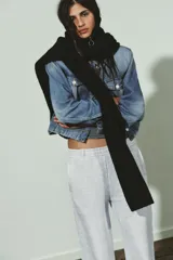 Bufanda de punto con cuello alto y cierre frontal con cremallera, diseñada con mangas largas integradas.