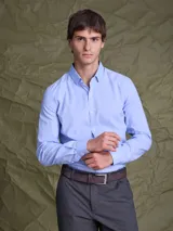 Camisa de vestir manga larga en color celeste, con cuello clásico y cierre frontal de botones. Presenta un corte entallado y puños con botones.