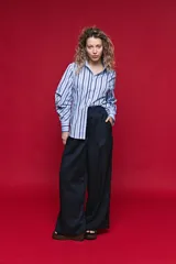Camisa de algodón celeste con rayas verticales azul marino y marrón, cuello camisero clásico y cierre frontal de botones nacarados.