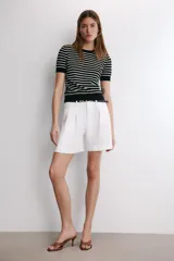 Jersey de punto de manga corta con cuello redondo, a rayas horizontales blancas y negras.