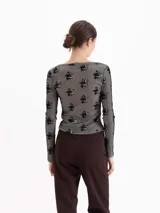 Top de manga larga confeccionado en tejido de punto con estampado de flores sobre fondo a rayas. Presenta un escote amplio y redondeado y un ajuste al cuerpo.