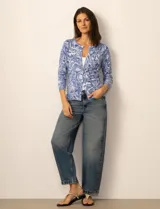 Cardigan de punto con estampado de mariposas en tonos grises y blancos. Presenta cuello redondo, cierre frontal con botones y mangas tres cuartos con puños acanalados.