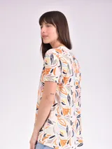 Remera blanca con estampado abstracto en color marrón.