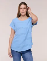 Blusa celeste de tejido pointelle calado, con escote redondo, mangas cortas con dobladillo y presilla con botón, y ruedo curvo.