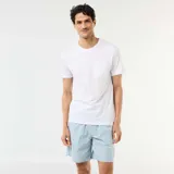 Pack de pijama corto compuesto por una remera blanca de manga corta con bolsillo en el pecho y un pantalón corto de popelina a rayas celestes, blancas y naranjas con cintura elástica.