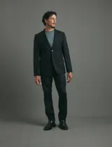 Traje de corte clásico compuesto por saco de dos botones con solapas tradicionales y pantalón de vestir a juego. Confeccionado en tejido liso de poliéster.