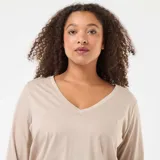 Camiseta de punto color beige con cuello en V y manga larga, de corte clásico y ajuste cómodo.