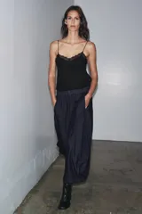 Pantalón ancho de denim azul oscuro, tiro medio, con cintura elástica ajustable mediante cordones interiores y pierna muy ancha con volumen que termina en un ruedo redondeado.