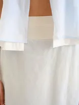 Pollera larga de lino color celeste con diseño superpuesto en capas de tonos claros.