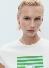 Remera blanca de manga corta y cuello redondo, confeccionada en 100% algodón, con diseño recto y estampado frontal.