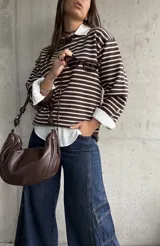 Sweater de punto a rayas horizontales en color chocolate y blanco, con cuello redondo y mangas largas con detalle de botones en los puños.