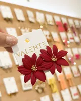 Aros caravanas colgantes con diseño de flor roja de acabado mate y centro dorado.