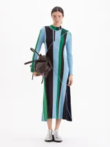 Vestido midi de punto acanalado con cuello medio alto y mangas largas. Presenta un diseño de rayas verticales en bloques de color azul, verde y marrón, con una línea diagonal decorativa que cruza el frente.