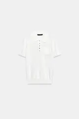 Top negro de punto fino con cuello polo, manga corta, cierre frontal de botones y un bolsillo de parche en el pecho.