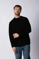 Sweater negro de tejido grueso con cuello redondo y corte relajado.