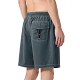 Boardshort de baño de corte holgado, color gris verdoso oscuro, con cintura elástica y cordón de ajuste negro. Presenta costuras blancas visibles y un pequeño parche cuadrado con el logo de la marca Former en la parte inferior del muslo derecho.