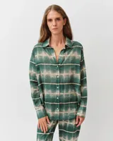 Camisa de corte recto color verde con estampado a cuadros en tonos beige, cuello camisero, cierre frontal con botones y mangas largas.