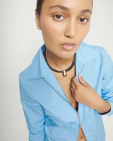 Collar de cuero negro con múltiples tiras y un colgante de bola grande de aleación de metales bañada en oro 18K. Cierre de mosquetón dorado con cadena de extensión.