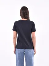 Remera blanca de manga corta y cuello redondo, con estampa frontal ilustrada de una mujer con boina y vestido con patrón animal print.