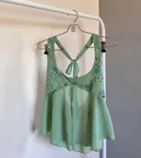 Top con escote halter, con detalles de lentejuelas y encaje, con abertura central.