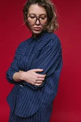 Camisa de manga larga con diseño de rayas verticales y horizontales en color marrón. Presenta un corte oversize con hombros caídos, cuello clásico y cierre frontal con botones.