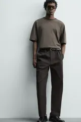 Pantalón chino regular fit de color negro, confeccionado en tejido de algodón. Cuenta con bolsillos frontales, detalle de bolsillo cerillero, bolsillos traseros de doble vivo y cierre frontal con cremallera y botón.