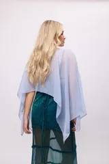 Poncho corto de chiffon color amarillo verdoso con textura plisada y brillo metálico. Presenta un cuello redondo y mangas amplias tipo capa.