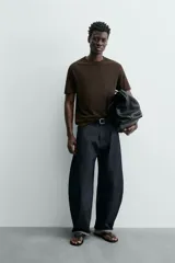 Camiseta de corte relajado (relaxed fit) color blanco roto o crema, con cuello redondo y manga corta.