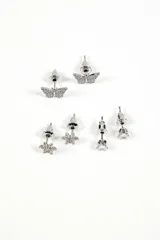 Set de tres pares de caravanas plateadas con strass: un par con forma de mariposa, otro con forma de flor y otro con un strass solitario.