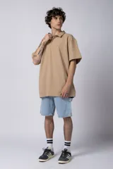 Chomba de manga corta con cuello polo, confeccionada en tejido de punto acanalado de textura pesada. Presenta un calce relajado y cuenta con una pequeña etiqueta distintiva en el ruedo.