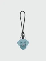 Llavero Longchamp con diseño de cabeza de perro en gamuza color celeste, con argolla metálica plateada y correa de cuero negra.