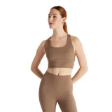 Top deportivo New Balance color marrón, de calce ajustado y breteles anchos. Confeccionado en tejido acanalado de poliéster reciclado y elastano, con tecnología NB DRY de secado rápido y almohadillas removibles.