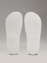 Ojotas blancas de Calvin Klein Jeans, con capellada de lona con logo estampado en negro.
