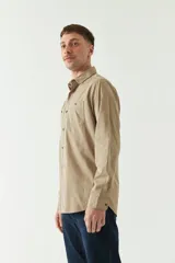 Camisa de gabardina color gris oscuro, con corte slim, manga larga, cuello clásico, cartera abotonada y dos bolsillos frontales con solapa.