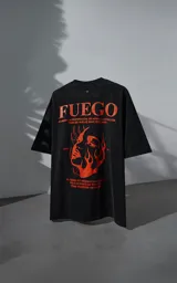 Remera de manga corta con cuello redondo y calce oversize, color negro con efecto nevado. Presenta una estampa frontal en color naranja con diseño gráfico de un rostro rodeado de llamas y texto tipográfico.