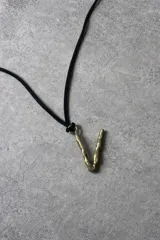 Collar de tiento de cuero con dije de bronce en forma de letra y placa metálica grabada con la marca.