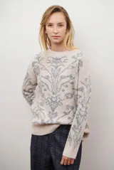 Buzo de tejido de punto en color marrón con un patrón ornamental floral en color celeste. Presenta cuello redondo, mangas largas y un corte holgado.