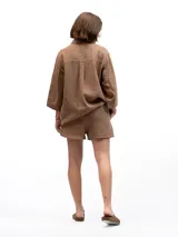 Shorts color marrón, confeccionados en lino, con cintura elástica y dos bolsillos laterales.