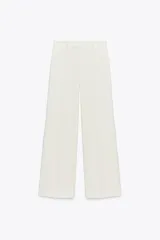 Pantalón de vestir blanco, tiro alto, con pierna recta ancha y bolsillos delanteros. Cierre frontal con cremallera, botón interior y gancho metálico.