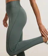 Legging deportiva de tiro alto confeccionada en microfibra elástica, con diseño ajustado al cuerpo y detalle de costuras sobrepuestas.