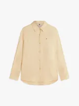 Camisa de lino puro color beige, de corte amplio y mangas largas, con cuello inglés, cierre frontal de botones y logo bordado en el pecho. Marca Tommy Hilfiger.