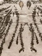 Mantel rectangular de algodón color crudo con estampado botánico en tonos marrones y verdes.