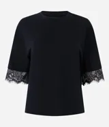 Remera de corte recto y calce confortable, confeccionada en algodón. Presenta cuello redondo y mangas cortas amplias con delicada aplicación de encaje en los bordes.